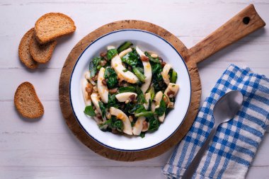 Pazı ve ıspanakla pişirilmiş mürekkep balığı. İspanyol geleneksel İspanyol mezeleri. 