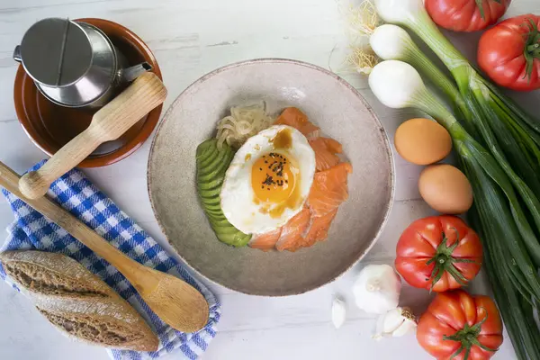 Kızarmış yumurta, avokado, soğan, kırmızı biber ve diğer sebzelerle birlikte teriyaki somon donburi. Tipik Japon yemeği..