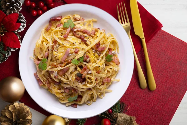 Spaghetti Carbonara. Christmas food served on a table decorated with Christmas motifs.