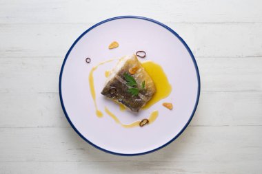 Bacalao al pil Kuzey İspanya 'dan geleneksel tapa. Yağdan, morina balığından ve sarımsaktan yapılan lezzetli bir sosla pişirilmiş morina balığı..