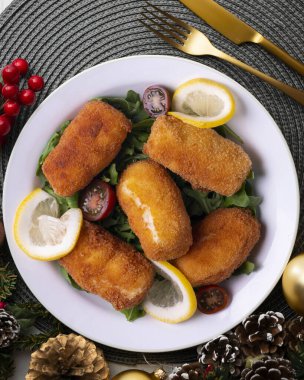 Balık kroket. İspanya 'nın kıyı bölgelerinin geleneksel tapaları. Noel motifleriyle süslenmiş bir masada servis edilen Noel yemeği..