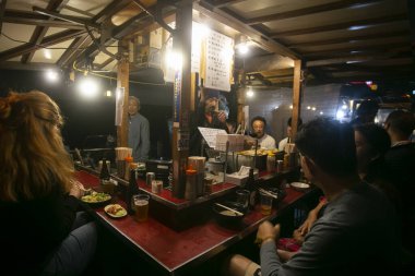 Fukuoka, Japonya; 1 Ekim 2023: İnsanlar Hakata Körfezi 'nde bir Yatai' de yiyip içiyorlar. Yatai, Japonya 'da ramen veya diğer yiyecekleri satan küçük bir yiyecek dükkanıdır..