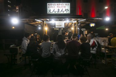 Fukuoka, Japonya; 1 Ekim 2023: İnsanlar Hakata Körfezi 'nde bir Yatai' de yiyip içiyorlar. Yatai, Japonya 'da ramen veya diğer yiyecekleri satan küçük bir yiyecek dükkanıdır..