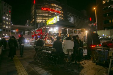 Fukuoka, Japonya; 1 Ekim 2023: İnsanlar Hakata Körfezi 'nde bir Yatai' de yiyip içiyorlar. Yatai, Japonya 'da ramen veya diğer yiyecekleri satan küçük bir yiyecek dükkanıdır..