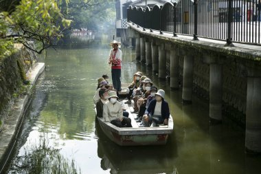Yanagawa, Japonya; 10 Ekim 2023: Fukuoka 'daki Yanagawa şehrinin yetenekli kayıkçılar tarafından işletilen tekneleriyle birlikte gezmek için güzel kanalları vardır..