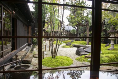 Japonya 'nın Murakami şehrinde geleneksel bir çay evinde taş heykeli olan geleneksel Japon bahçesi..