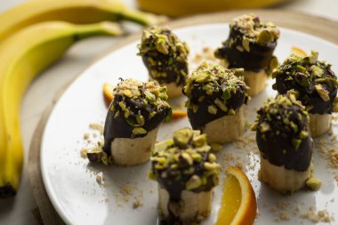 Koyu çikolata ve şam fıstığı kaplı muz parçaları..