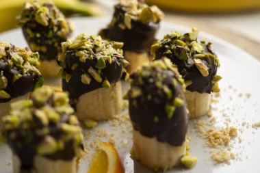 Koyu çikolata ve şam fıstığı kaplı muz parçaları..