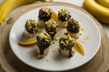 Koyu çikolata ve şam fıstığı kaplı muz parçaları..