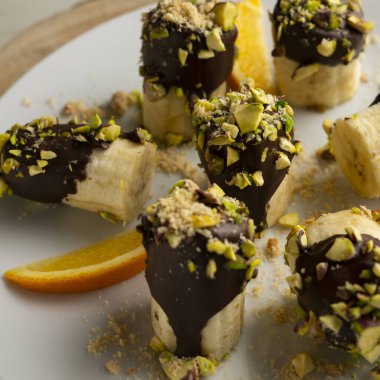 Koyu çikolata ve şam fıstığı kaplı muz parçaları..