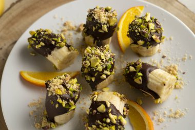 Koyu çikolata ve şam fıstığı kaplı muz parçaları..