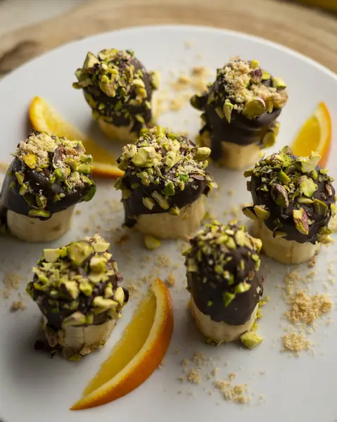 Koyu çikolata ve şam fıstığı kaplı muz parçaları..