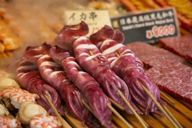 Tokyo, Japonya 'daki Tsukiji Dış Pazarı' ndaki bir gıda standında mürekkep balığı..