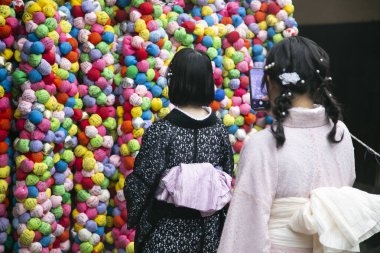 Kyoto, Japonya; 10 Ekim 2023: Tapınağın birçok yerinde elleri ve ayakları bağlı bir maymun olan Kukurizaru 'yu temsil eden renk topları asılı