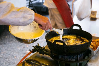 Japon aşçı Tokyo 'da kızgın yağlı bir alıcıda tempura pişiriyor..