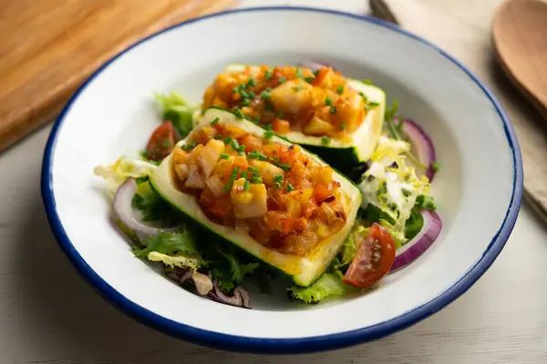 Zucchini stuffed with vegetables and fresh hake.