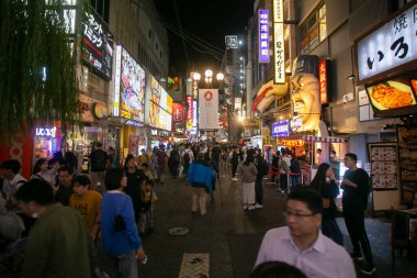 Osaka, Japonya; 20 Ekim 2023: Dotonbori caddelerinde sokak yemekleri ve gece hayatı dolu restoranlar ve turistler.