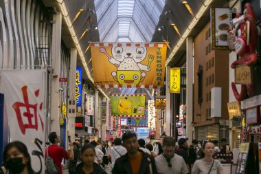 Osaka, Japonya; 20 Ekim 2023: Dotonbori caddelerinde sokak yemekleri ve gece hayatı dolu restoranlar ve turistler.