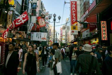 Osaka, Japonya; 20 Ekim 2023: Dotonbori caddelerinde sokak yemekleri ve gece hayatı dolu restoranlar ve turistler.