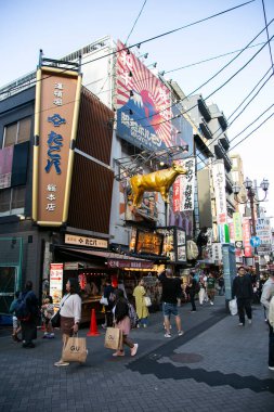 Osaka, Japonya; 20 Ekim 2023: Dotonbori caddelerinde sokak yemekleri ve gece hayatı dolu restoranlar ve turistler.
