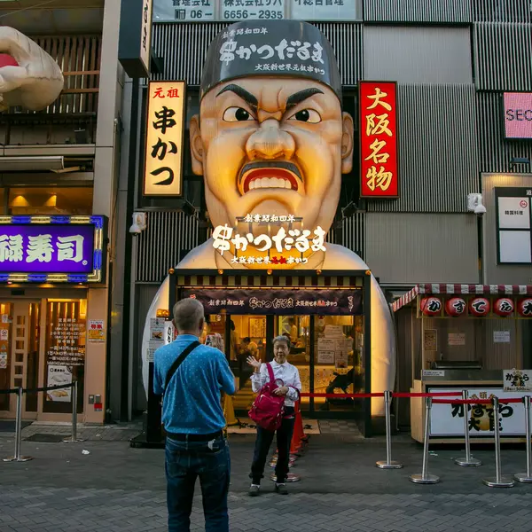 Osaka, Japonya; 20 Ekim 2023: Dotonbori caddelerinde sokak yemekleri ve gece hayatı dolu restoranlar ve turistler.