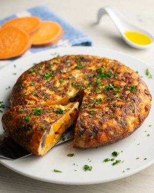 Tatlı patates, soğan ve yumurtalı İspanyol omleti. İspanyol gastronomisinin geleneksel tapası.