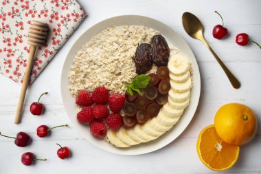 Lezzetli ve sağlıklı yulaf ezmesi, ahududu, hurma, üzüm ve muz..