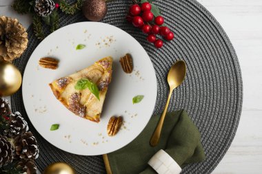 Taze armutlu lezzetli pasta ve Noel süslemeleri olan bir masada kuru üzüm..