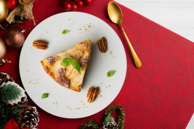 Taze armutlu lezzetli pasta ve Noel süslemeleri olan bir masada kuru üzüm..