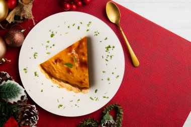 Amerikan balkabağı turtasının leziz bir parçası Noel süslemeleri olan bir masanın üstünde..