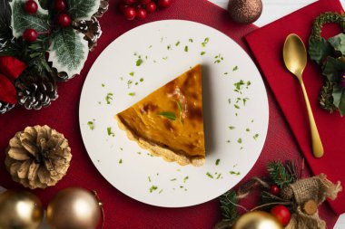 Amerikan balkabağı turtasının leziz bir parçası Noel süslemeleri olan bir masanın üstünde..