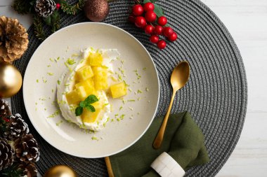 Masada taze ananas ve krema ile nefis bir tatlı ve Noel süsü..