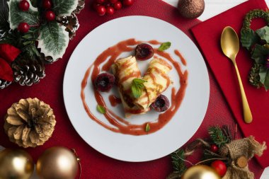 Kiraz soslu krep hamurlu lezzetli börekler. Noel süslemeleri ile süslenmiş masa.