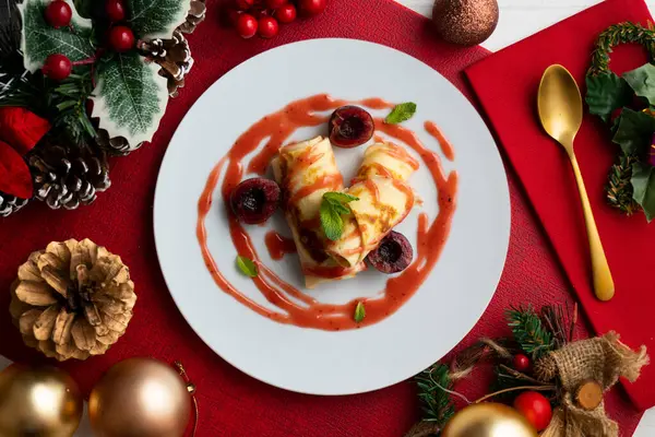 Kiraz soslu krep hamurlu lezzetli börekler. Noel süslemeleri ile süslenmiş masa.