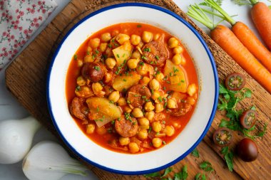 Baharatlı sucuklu bezelye ile pişirilmiş lezzetli bir yemek. Üst manzara yemek masası.