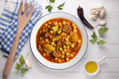 Baharatlı sucuklu bezelye ile pişirilmiş lezzetli bir yemek. Üst manzara yemek masası.