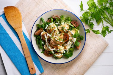 Kızarmış karnabahar salatası ve sebze ve yoğurt sosu. Üst manzara yemek masası.