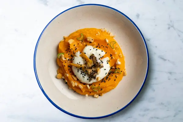 Stock image Sweet potato cream with poached egg and mushrooms. Top view table.