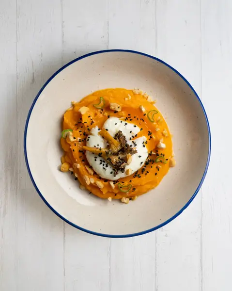 stock image Sweet potato cream with poached egg and mushrooms. Top view table.