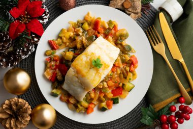 Fırında sebzeli morina geleneksel İspanyol tarifi. Masada Noel süslemeleri var..