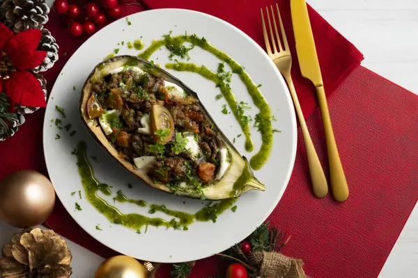 stock image Eggplant stuffed with tomato and baked mozzarella. Food on a Christmas decorated table.