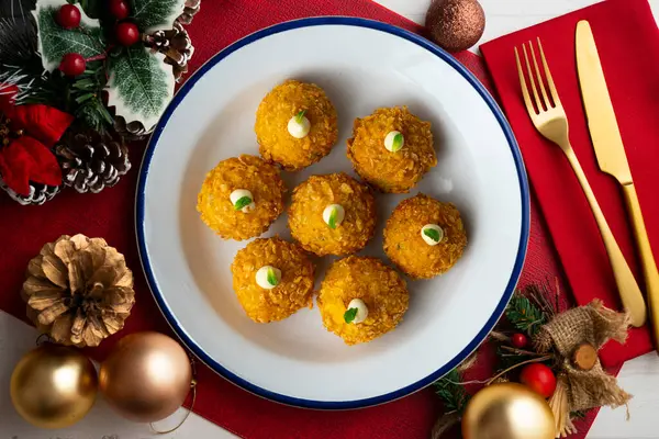 stock image Spanish Tapa croquettes made with bechamel sauce and stuffed fish and mayonnaise. Top view table with christmas decoration.