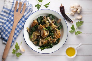 Ispanak ve kuru üzümle pişirilmiş lezzetli tavşan. Üst görünüm tablosu