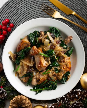 Ispanak ve kuru üzümle pişirilmiş lezzetli tavşan. Noel süslemeleri ile en üstteki görünüm masası.