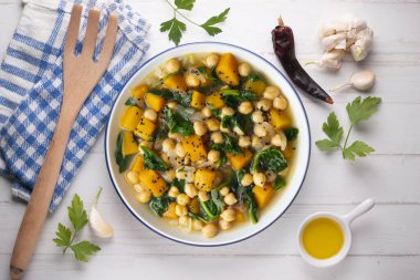 Balkabağı ve ıspanaklı nohut yahnisi. Dekorasyonlu üst görünüm tablosu.