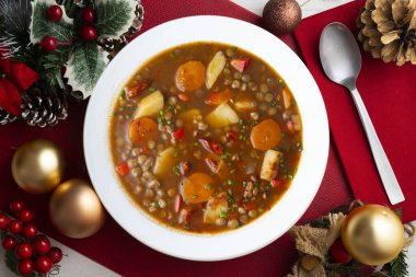 Spicy stewed lentils with vegetables and potatoes. Top view table with Christmas decoration.