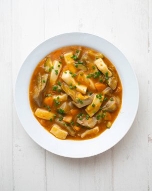 Patates, enginar ve sebzeli kalamar güveci. Dekorasyonlu üst görünüm tablosu.