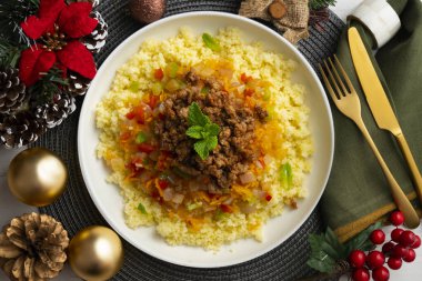 Couscous salad with vegetables and minced meat. Top view table with christmas decoration. clipart