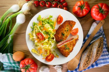 Asturian Cachopo 'su. Peynir ve biberle doldurulmuş dana fileto. Dekorasyonlu üst görünüm tablosu.