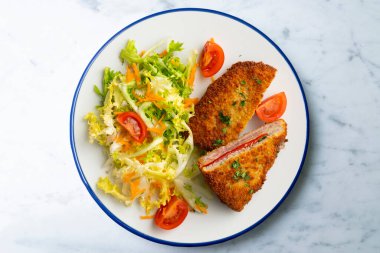 Asturian Cachopo 'su. Peynir ve biberle doldurulmuş dana fileto. Dekorasyonlu üst görünüm tablosu.